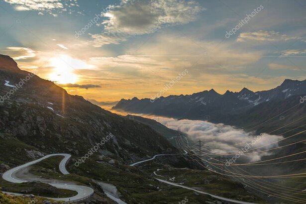 Convertible on a winding Swiss alpine pass at sunset